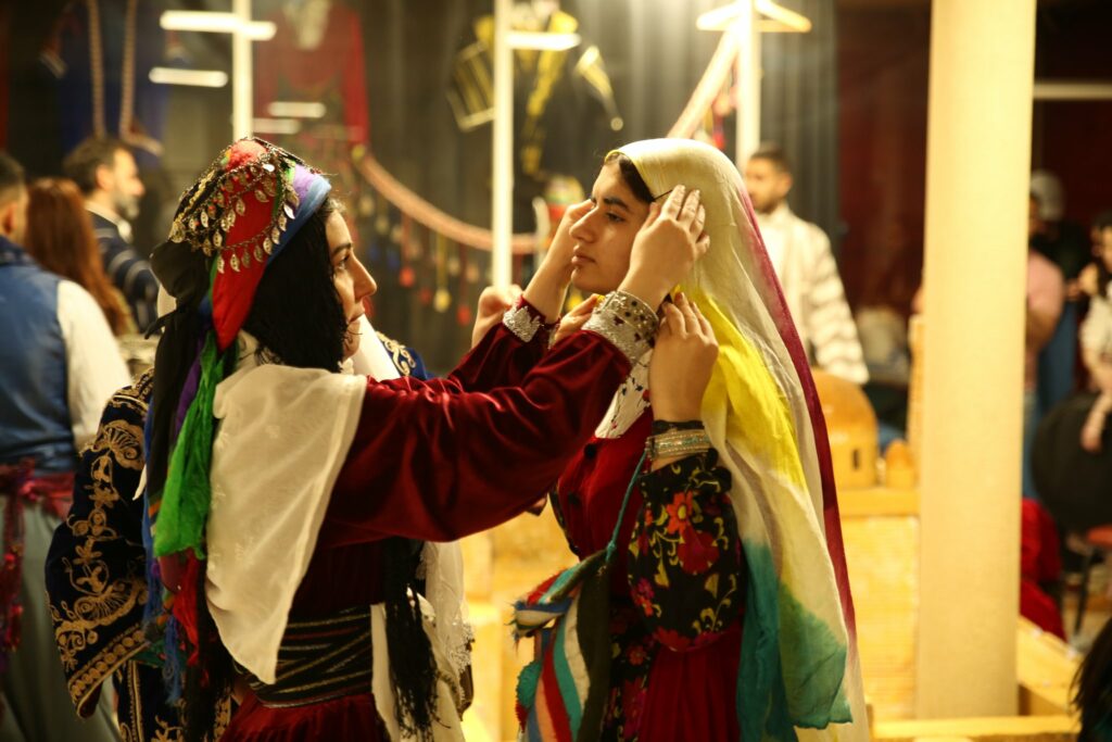 Deux jeunes femmes se préparant en tenues traditionnelles kurdes
